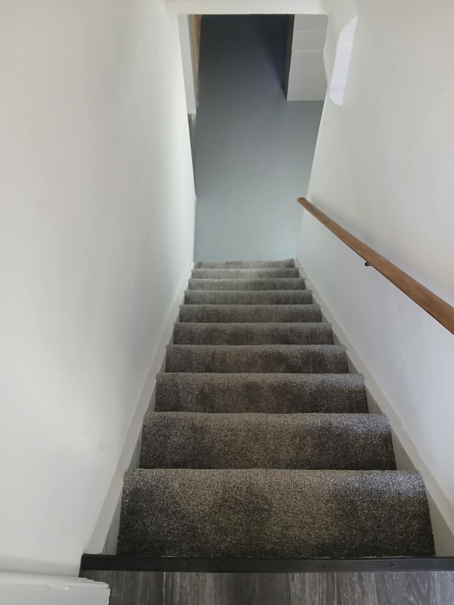 stairs featuring wood finished floors