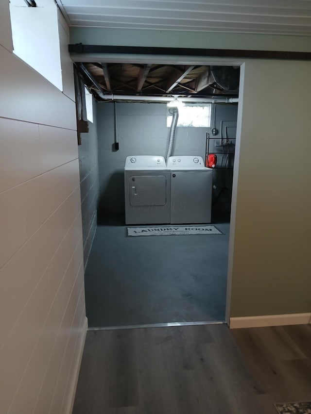laundry room featuring wood finished floors, laundry area, and washer and clothes dryer