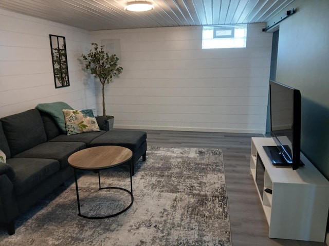 living area with wooden walls, wood finished floors, and wooden ceiling