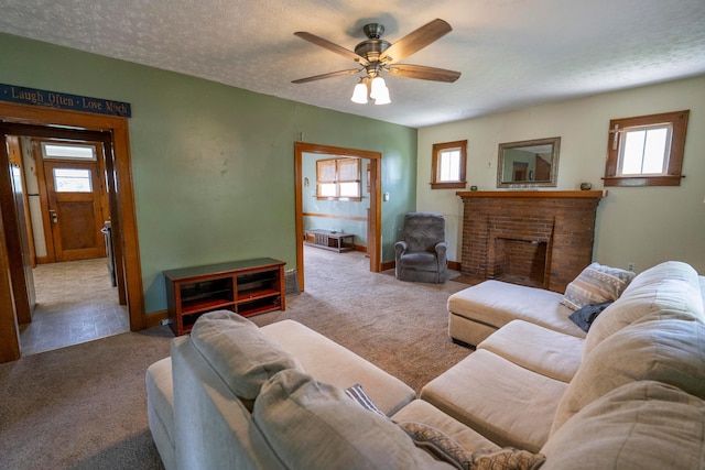 317 N High St, New Lexington, OH 43764 - carpeted living room featuring healthy amount of natural light, a ceiling fan, a fireplace, baseboards, and a textured ceiling