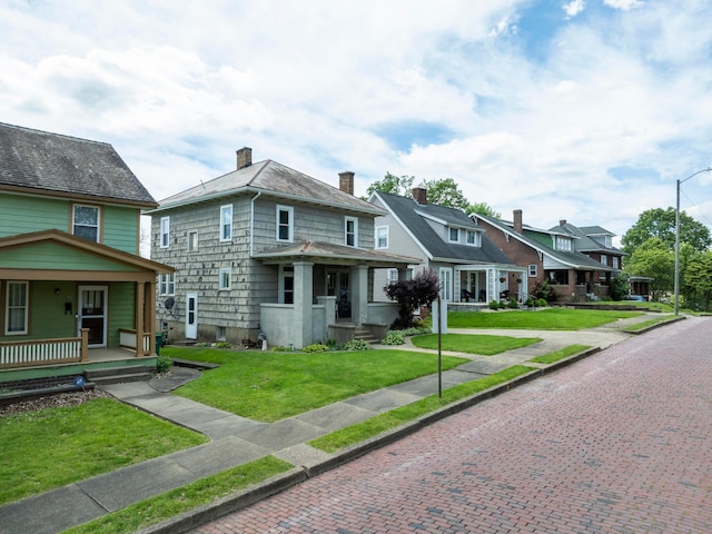 317 N High St, New Lexington, OH 43764 - view of front of home with a porch, a residential view, a front yard, and a chimney