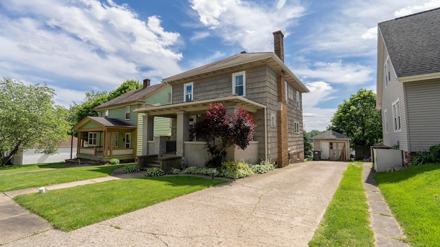 317 N High St, New Lexington, OH 43764 - american foursquare style home featuring a porch, a chimney, an outdoor structure, and a front yard