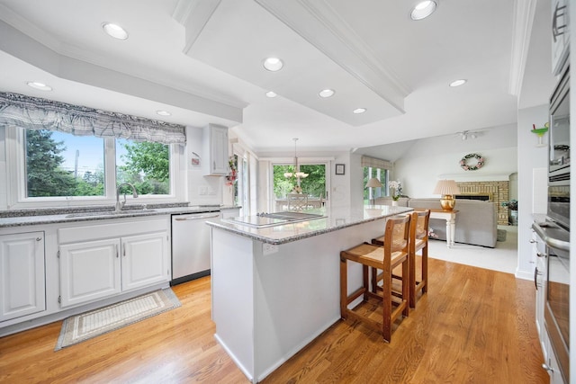 6180 Storm Haven Ct, Lewis Center, OH 43035 - kitchen featuring appliances with stainless steel finishes, a sink, open floor plan, light stone counters, and white cabinetry