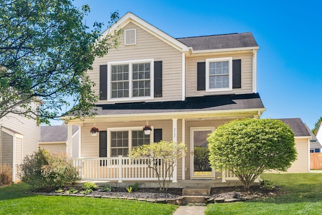 traditional-style home with a porch, roof with shingles, and a front lawn