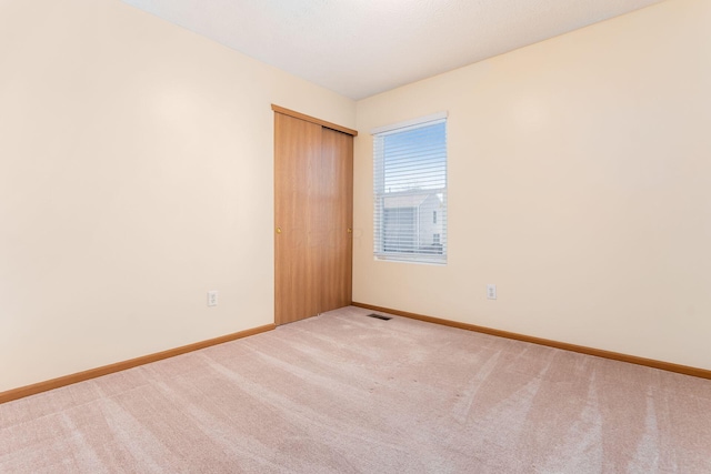spare room featuring baseboards, carpet, and visible vents