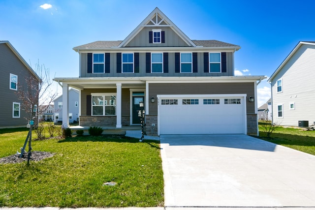 craftsman house with central AC unit, stone siding, board and batten siding, a porch, and a front yard