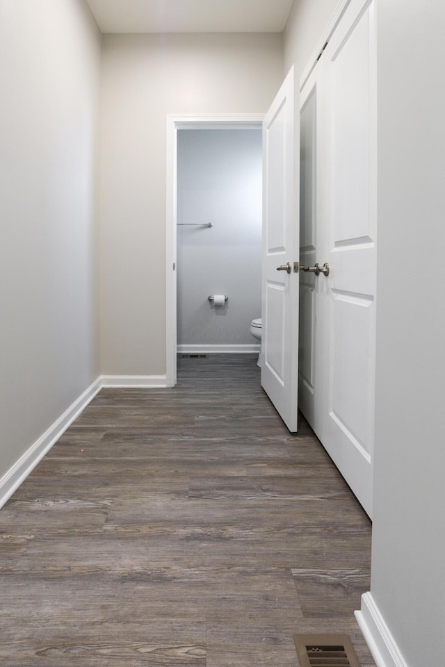 interior space with wood finished floors, visible vents, and baseboards
