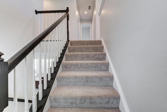 stairs featuring carpet, visible vents, and baseboards