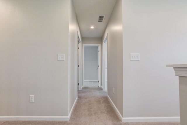 hallway with recessed lighting, visible vents, baseboards, and light colored carpet