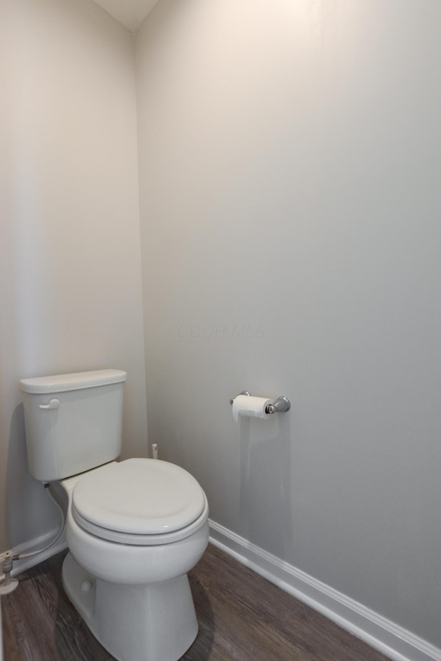bathroom featuring wood finished floors, toilet, and baseboards