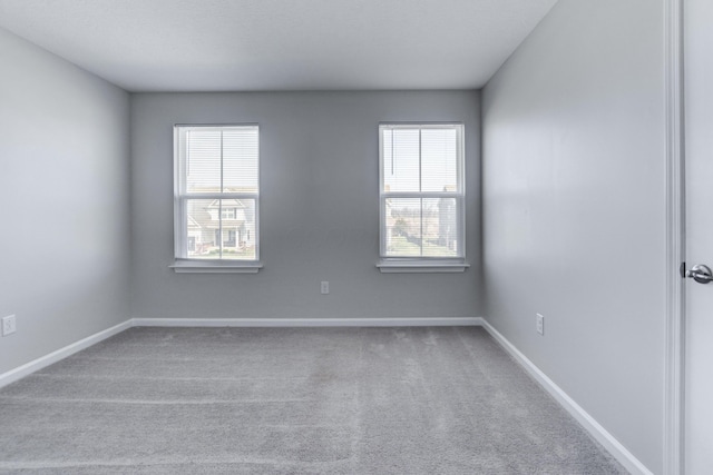carpeted spare room with baseboards