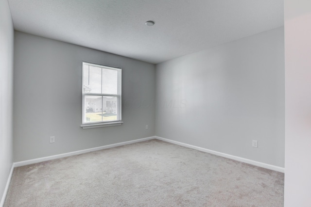 empty room with carpet and baseboards