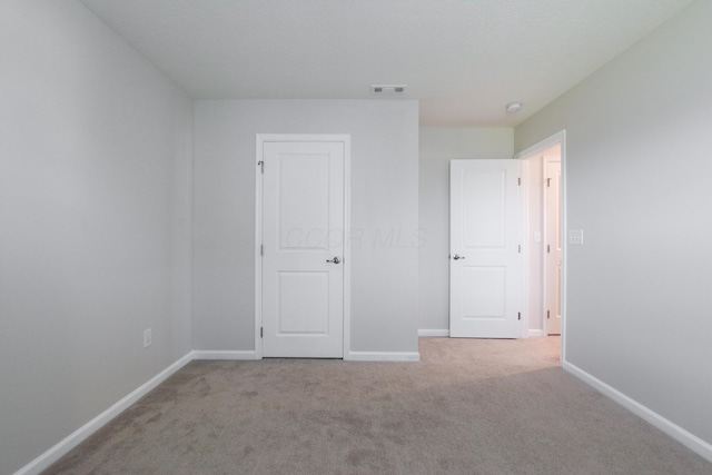 unfurnished bedroom featuring baseboards, visible vents, and carpet flooring