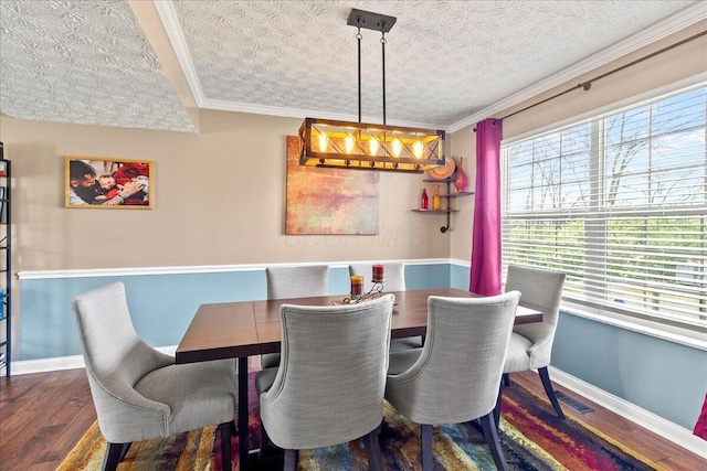 dining area featuring ornamental molding, baseboards, a healthy amount of sunlight, and wood finished floors