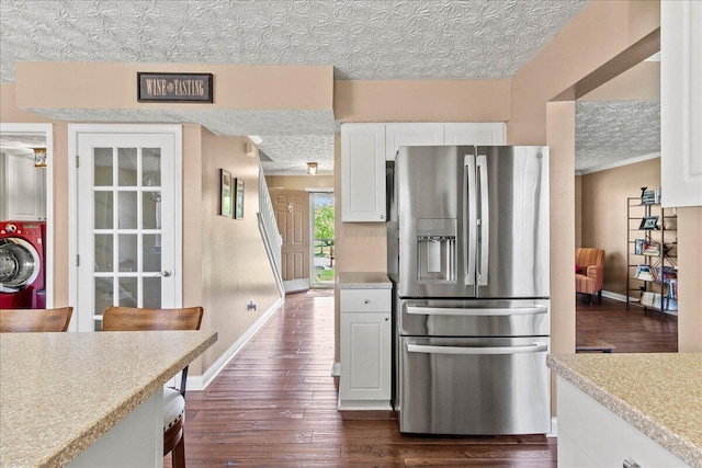 kitchen with stainless steel fridge, dark wood finished floors, white cabinetry, baseboards, and light countertops