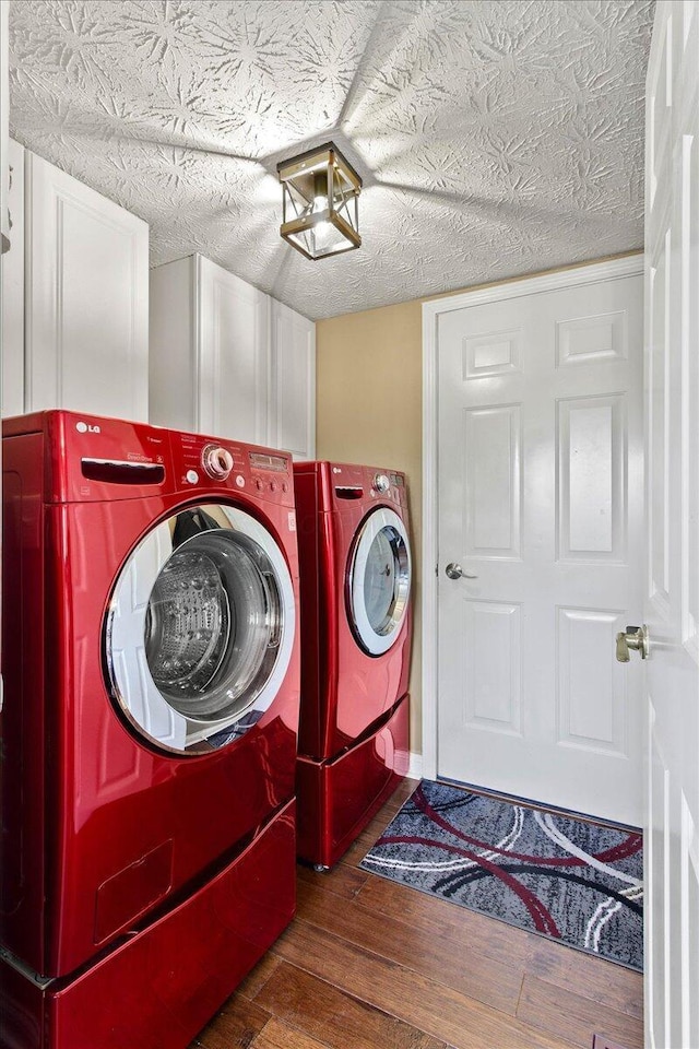 laundry room featuring cabinet space, wood finished floors, and washer and dryer