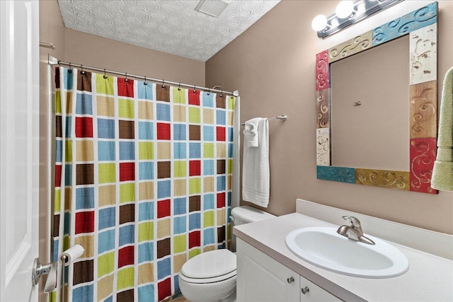 bathroom featuring vanity, toilet, a textured ceiling, and a shower with curtain