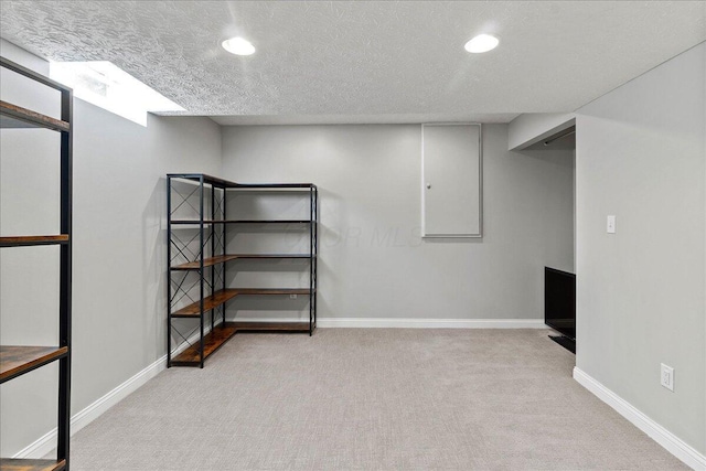 finished below grade area with recessed lighting, a textured ceiling, baseboards, and carpet floors