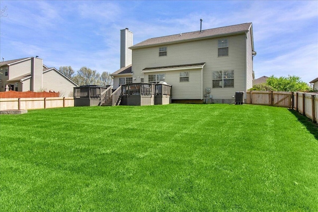 back of house with a yard, central AC unit, a chimney, and a fenced backyard