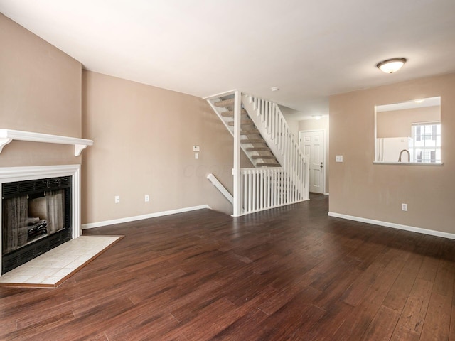5690 Kilbury Ln Unit 120D, Hilliard, OH 43026 - unfurnished living room with hardwood / wood-style flooring, a tiled fireplace, and stairs