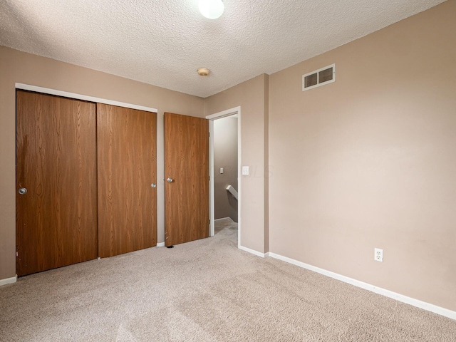 5690 Kilbury Ln Unit 120D, Hilliard, OH 43026 - unfurnished bedroom with carpet, a closet, and a textured ceiling