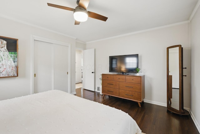 bedroom featuring crown molding, dark wood finished floors, a closet, ceiling fan, and baseboards