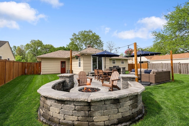 rear view of property featuring an outdoor living space with a fire pit and a patio