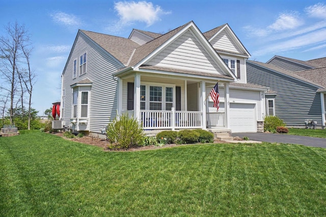 view of front of home with a shingled roof, a front lawn, driveway, and covered porch