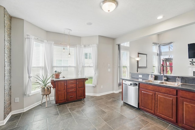 kitchen featuring a wealth of natural light, stainless steel dishwasher, baseboards, and a sink