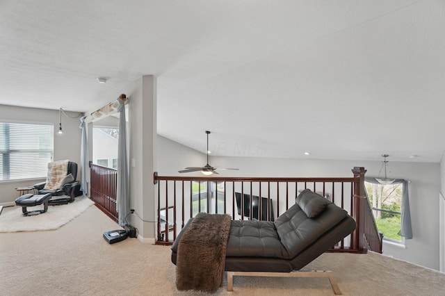 living area with a ceiling fan, carpet flooring, and a wealth of natural light