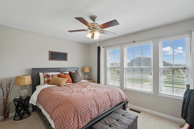 bedroom featuring light colored carpet, baseboards, multiple windows, and visible vents
