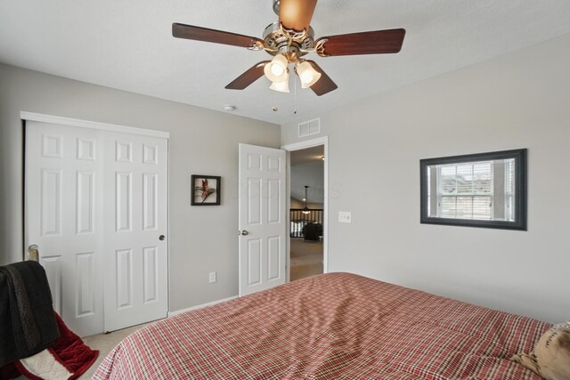 bedroom featuring a ceiling fan, visible vents, a closet, and light colored carpet