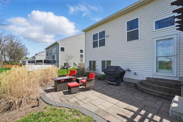 back of property with a fire pit and a patio
