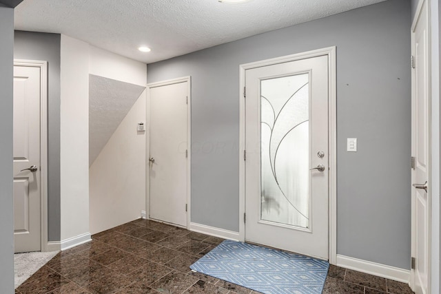 entrance foyer featuring baseboards, recessed lighting, and a textured ceiling