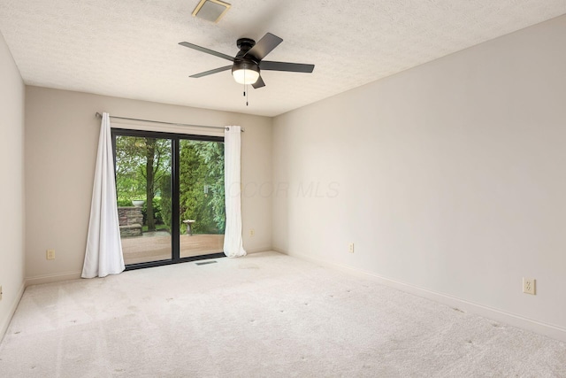 carpeted empty room with a ceiling fan, visible vents, and baseboards
