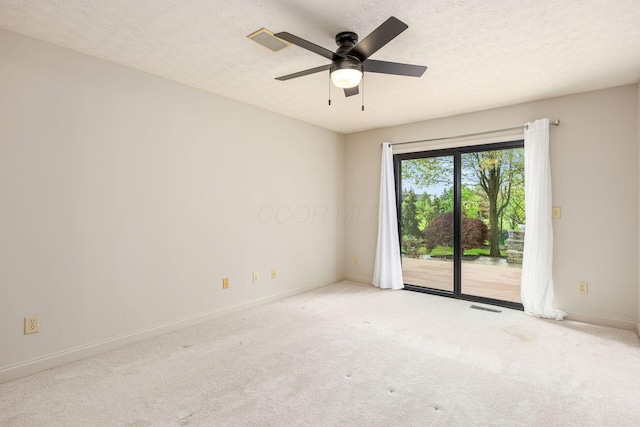 carpeted empty room with a textured ceiling, visible vents, ceiling fan, and baseboards
