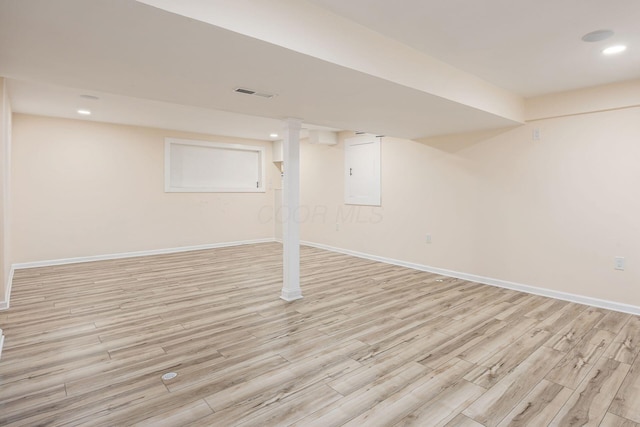 finished below grade area with light wood-style floors, recessed lighting, visible vents, and baseboards