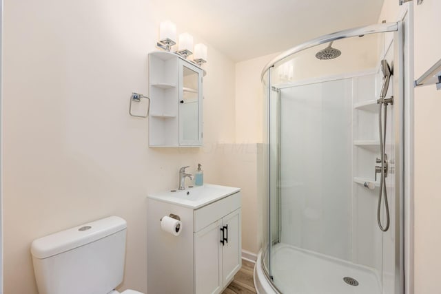 full bathroom with wood finished floors, vanity, toilet, and a stall shower