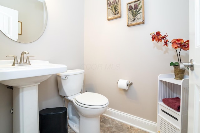 half bathroom with toilet and baseboards