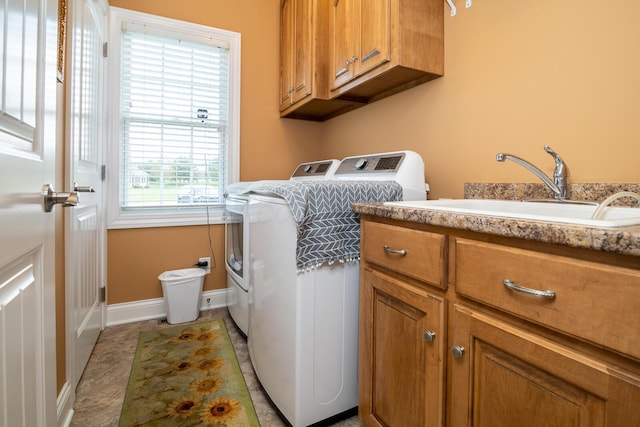 laundry area featuring washing machine and clothes dryer, baseboards, a sink, and cabinet space
