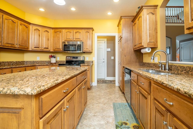 kitchen featuring a sink, appliances with stainless steel finishes, arched walkways, and light stone counters