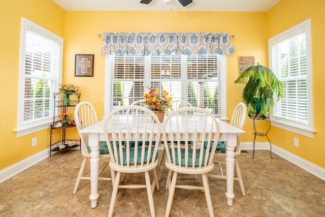 dining space with baseboards, ceiling fan, and a wealth of natural light