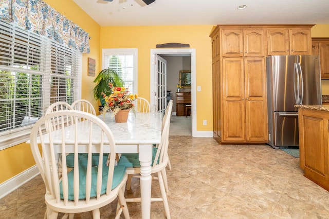 dining area with baseboards and ceiling fan