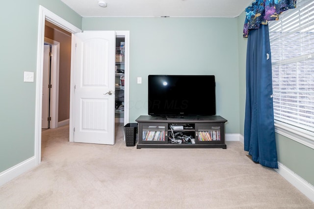 carpeted living room featuring baseboards