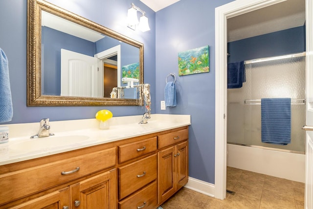 full bathroom featuring a sink, bath / shower combo with glass door, tile patterned flooring, and double vanity