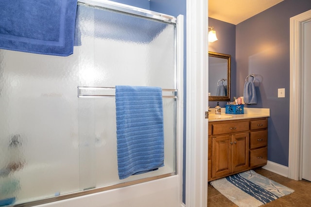full bath with tile patterned flooring, enclosed tub / shower combo, baseboards, and vanity