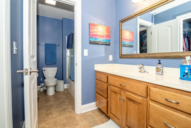 bathroom with vanity, baseboards, tile patterned floors, and toilet