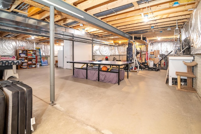 unfinished basement with freestanding refrigerator