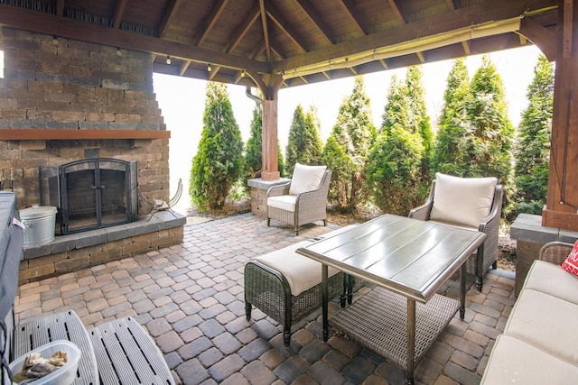 view of patio featuring an outdoor stone fireplace and a gazebo