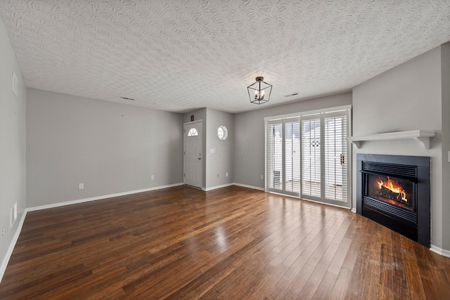 6709 Axtel Dr Unit 5A, Canal Winchester, OH 43110 - unfurnished living room featuring a textured ceiling, wood finished floors, baseboards, and a glass covered fireplace